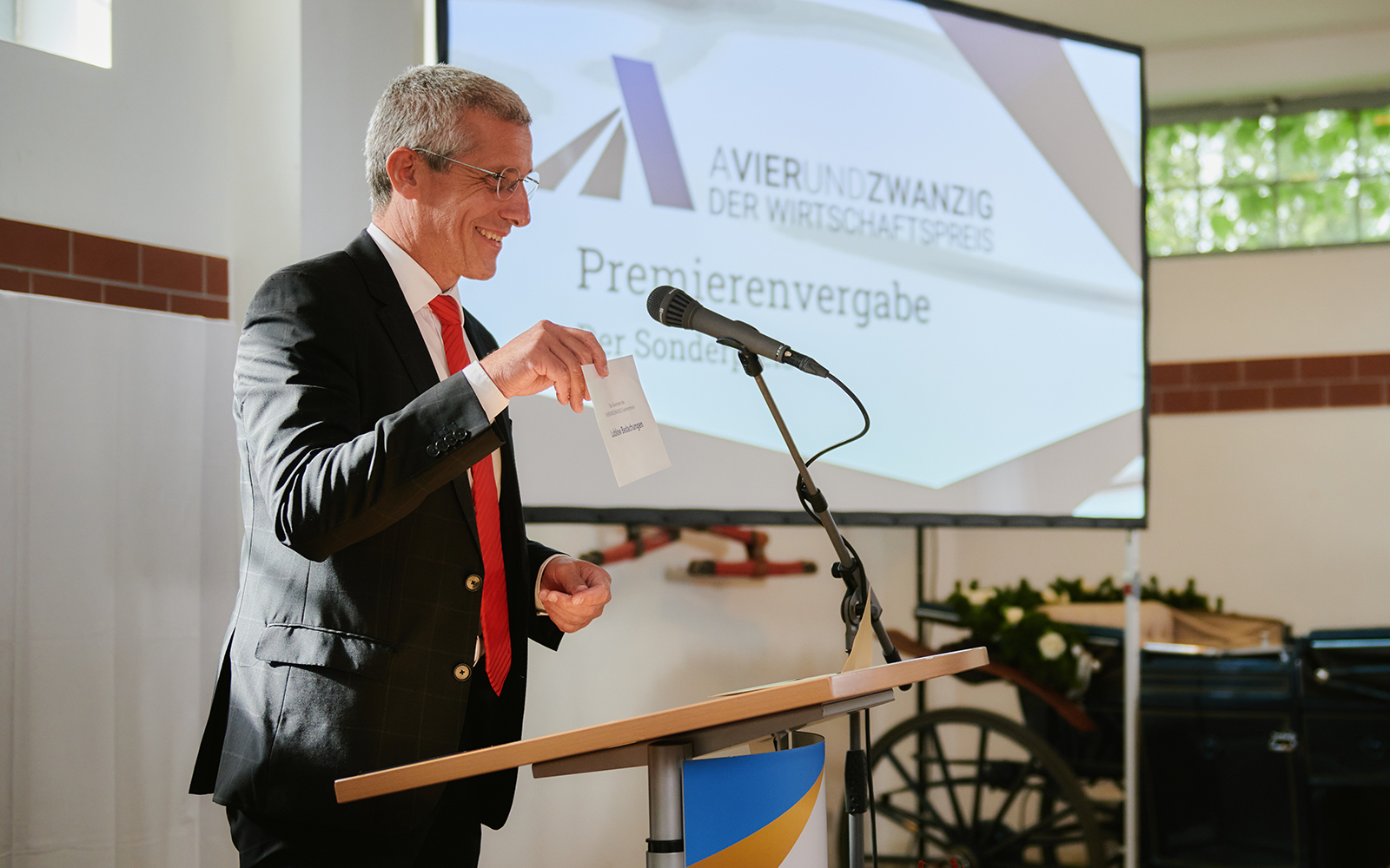 Das Foto zeigt Markus Rück (Vorstandsvorsitzender Sparkasse Ostprignitz Ruppin) bei einer Laudatio beim AVIERUNDZWANZIG Wirtschaftspreis 2022