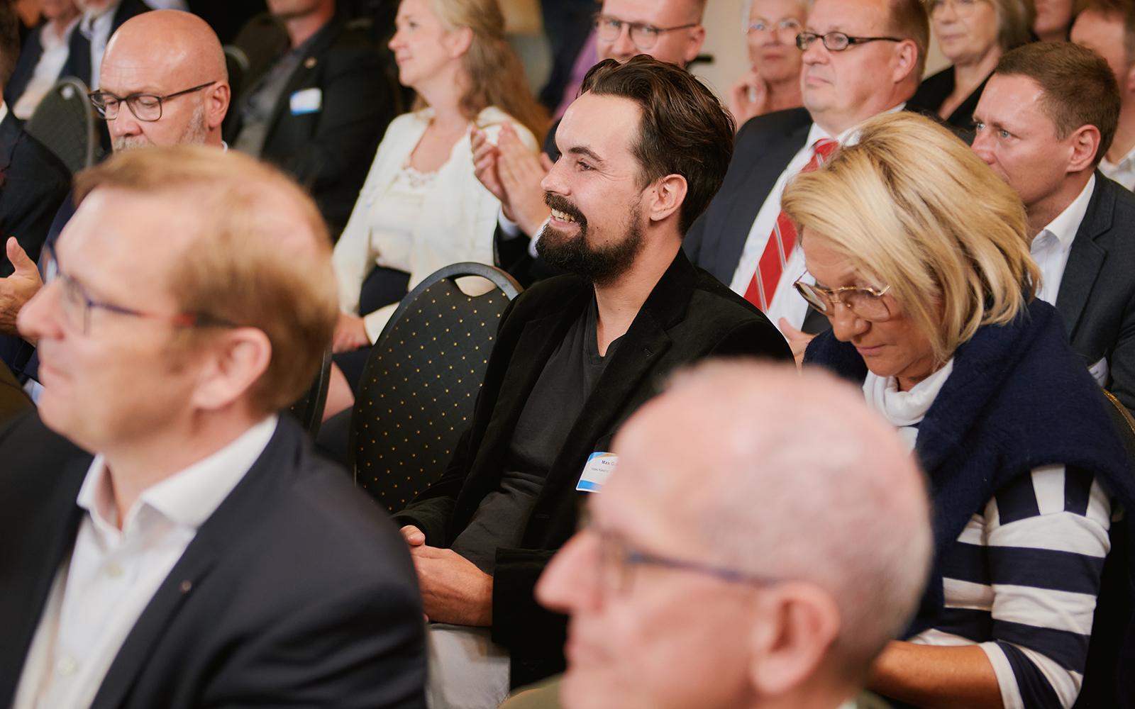 Das Foto zeigt Menschen im Publikum von der Seite bei der Preisverleihung des AVIERUNDZWANZIG Wirtschaftspreises 2022.